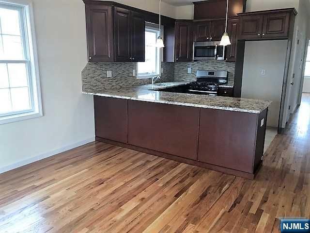 426 Jersey Street, Unit 1 GROUND Harrison, NJ 07029 - Photo 11 of 17 a kitchen with stainless steel appliances granite countertop a sink stove and refrigerator