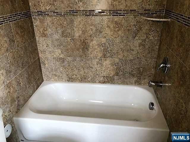 426 Jersey Street, Unit 1 GROUND Harrison, NJ 07029 - Photo 13 of 17 a bathroom with a bathtub