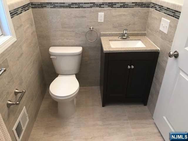 426 Jersey Street, Unit 1 GROUND Harrison, NJ 07029 - Photo 15 of 17 a bathroom with a toilet sink and mirror