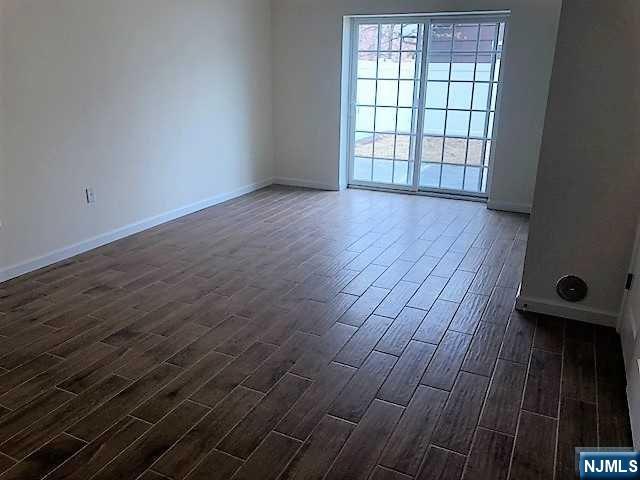 426 Jersey Street, Unit 1 GROUND Harrison, NJ 07029 - Photo 17 of 17 a view of an empty room with wooden floor and a window