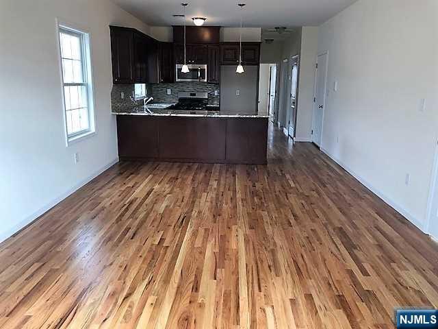 426 Jersey Street, Unit 1 GROUND Harrison, NJ 07029 - Photo 5 of 17 a kitchen with wooden floor and large window