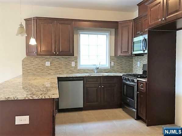 426 Jersey Street, Unit 1 GROUND Harrison, NJ 07029 - Photo 7 of 17 a kitchen with stainless steel appliances granite countertop a sink stove and refrigerator