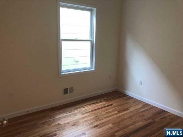 426 Jersey Street, Unit 1 GROUND Harrison, NJ 07029 - Photo 10 of 17 an empty room with wooden floor and a window
