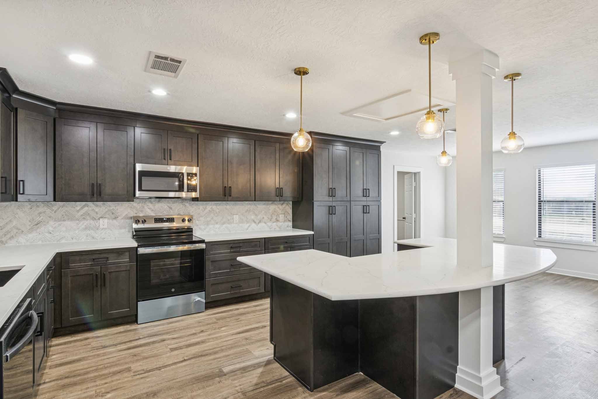 a kitchen with kitchen island a sink stainless steel appliances and wooden floor