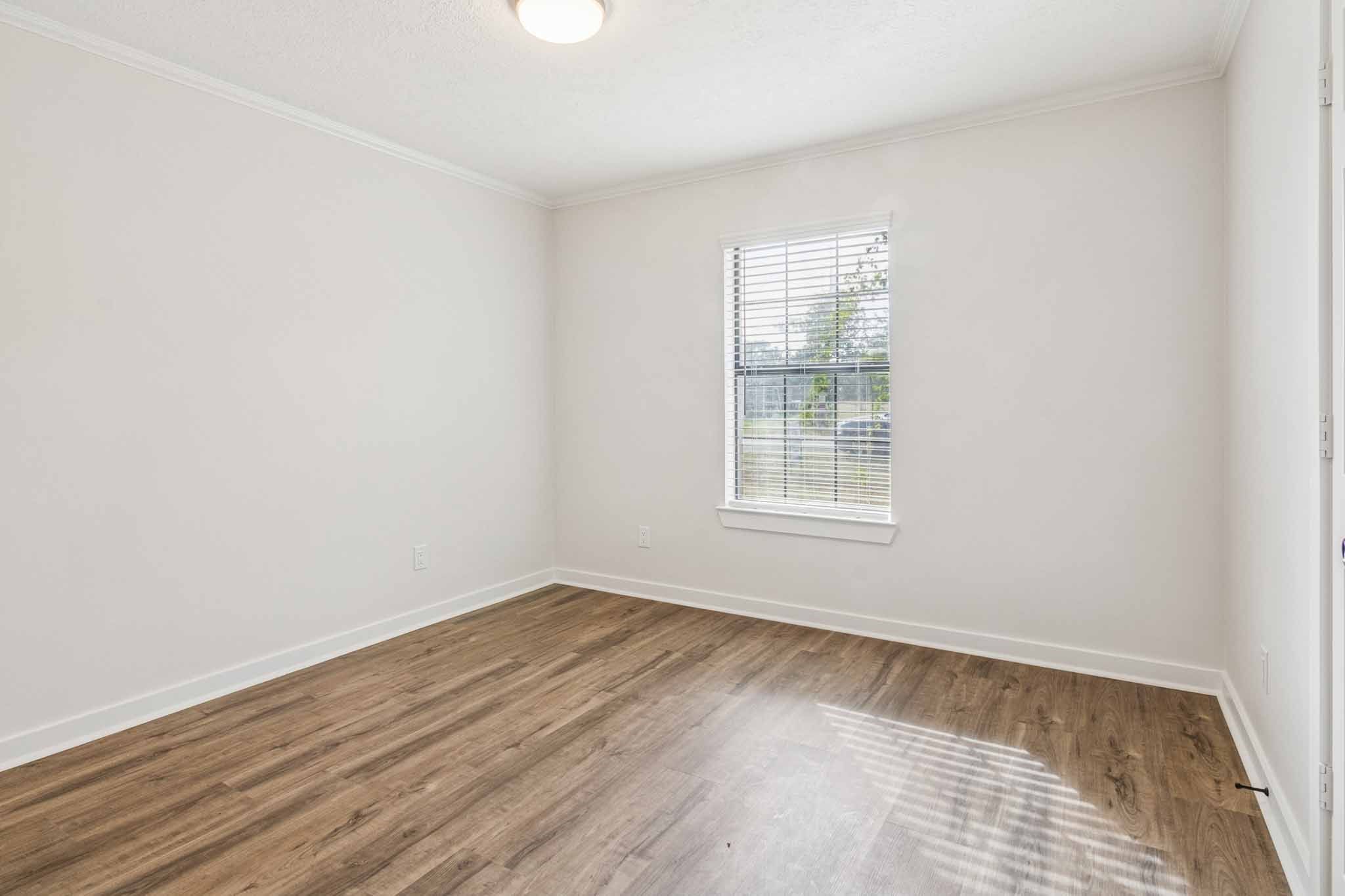 305 James Street Winnie, TX 77665 - Photo 20 of 25 an empty room with wooden floor and windows
