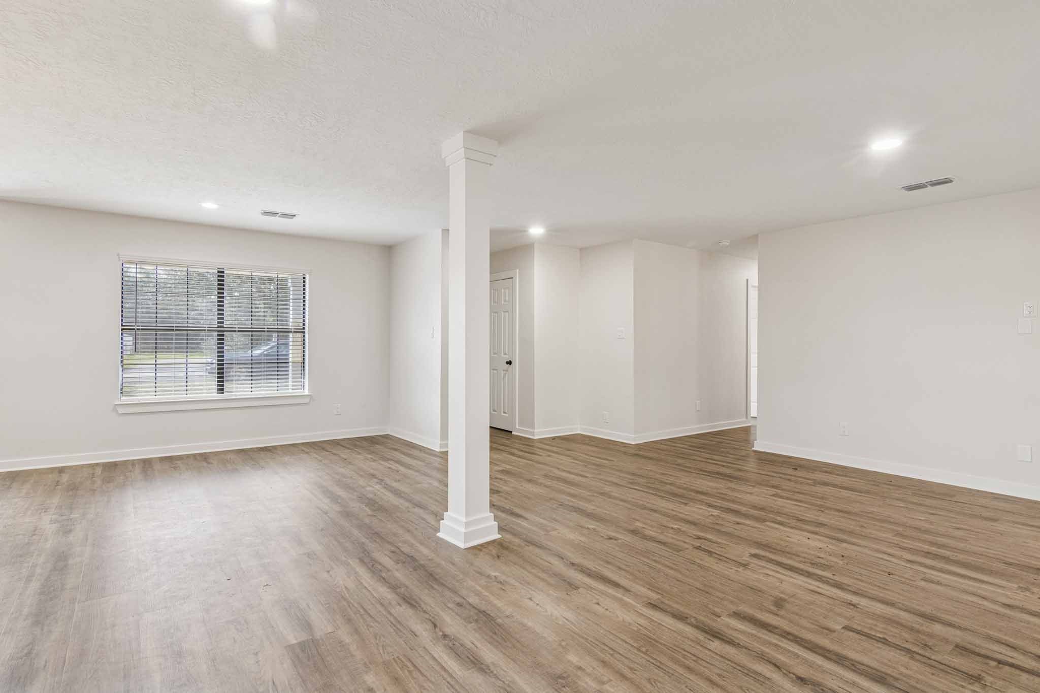 305 James Street Winnie, TX 77665 - Photo 6 of 25 a view of an empty room with wooden floor and a window