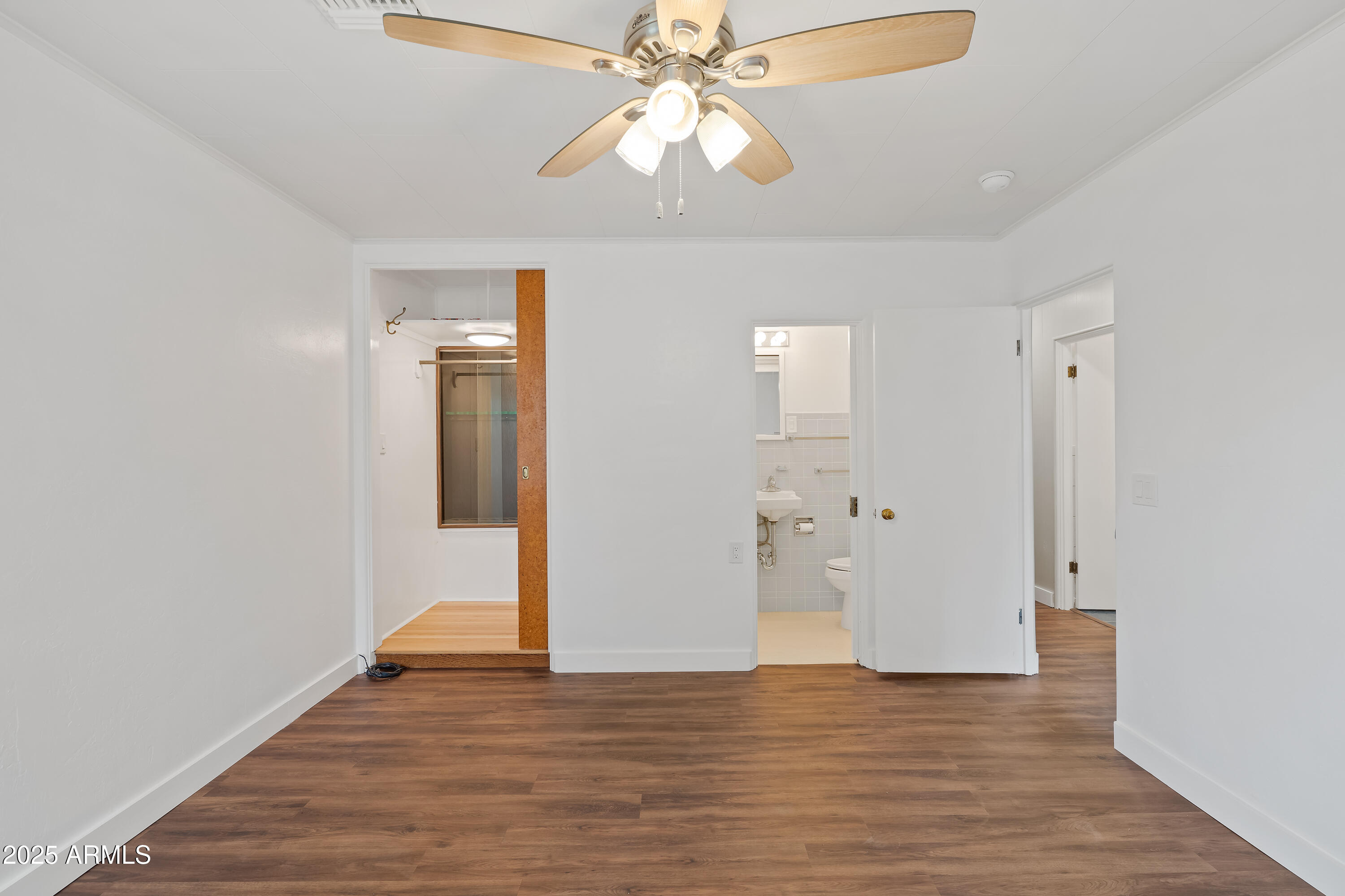 606 Oliver Circle Bisbee, AZ 85603 - Photo 10 of 30 a view of an empty room with wooden floor and a ceiling fan