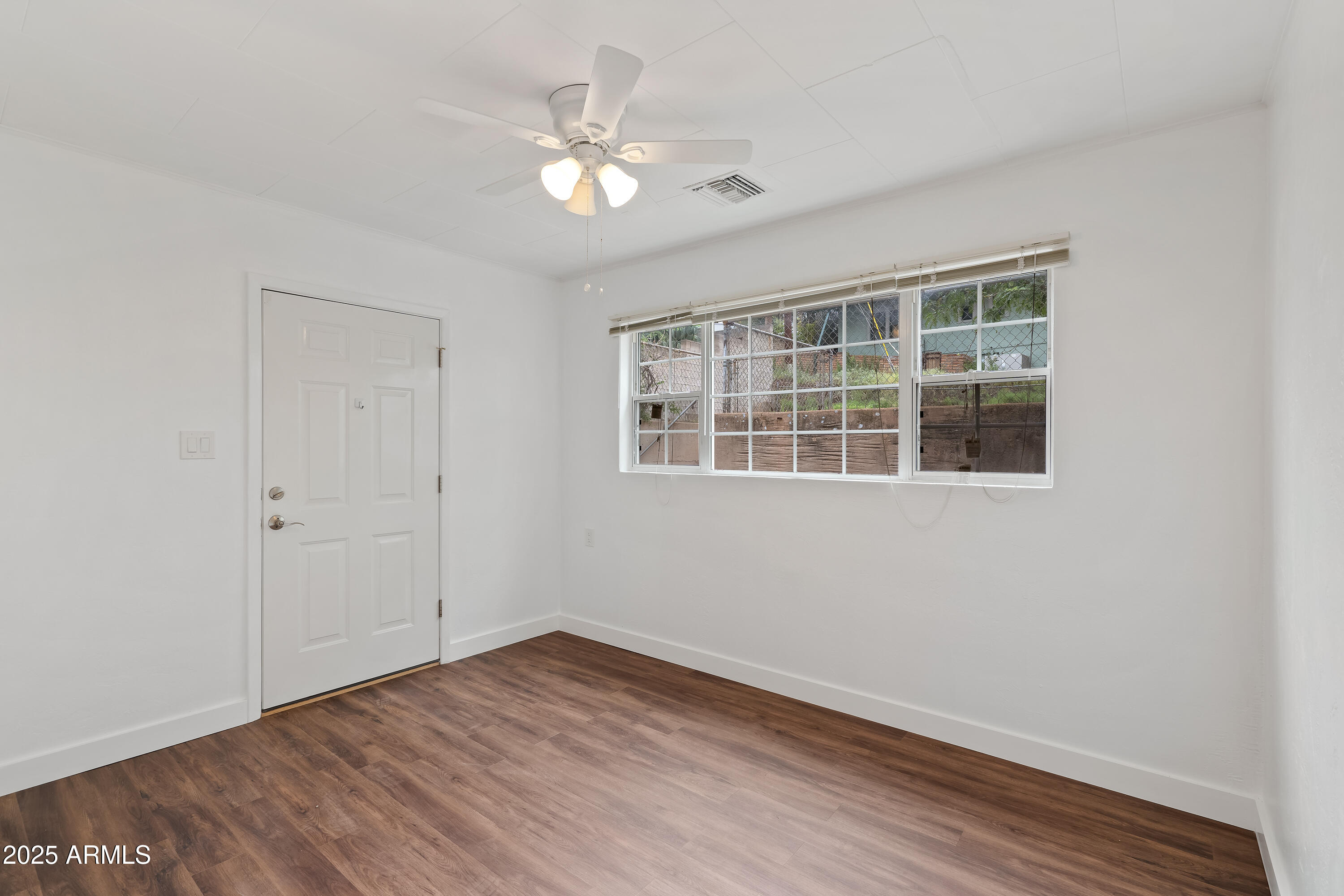 606 Oliver Circle Bisbee, AZ 85603 - Photo 14 of 30 a view of empty room with wooden floor and fan