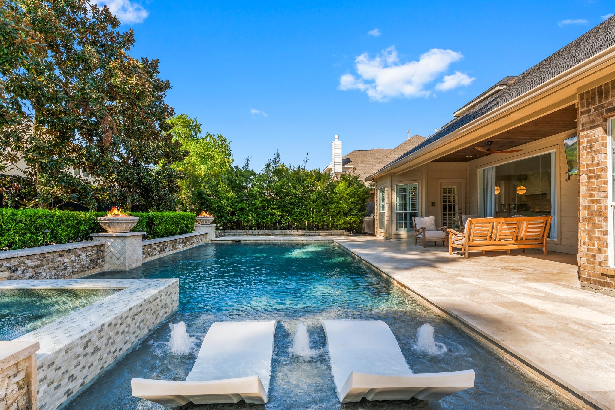 3126 Burton Ridge Drive Spring, TX 77386 - Photo 2 of 41 Resort-style backyard with custom pool, spa, tanning ledge, and water features. Covered patio and lush landscaping create a private outdoor retreat perfect for entertaining and everyday relaxation