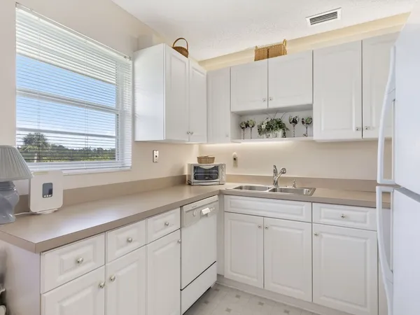 a kitchen with white cabinets and white appliances
