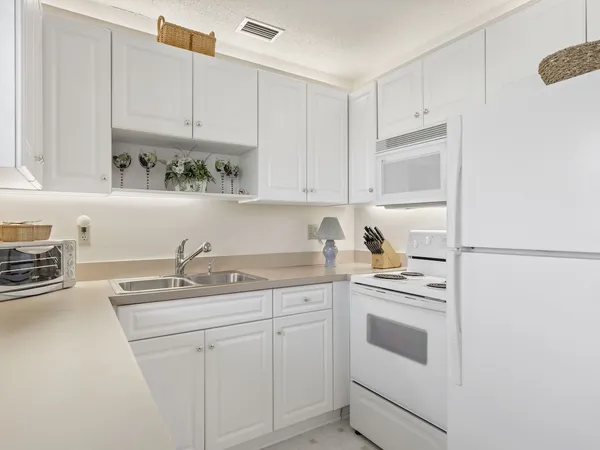 a kitchen with stainless steel appliances granite countertop white cabinets sink and stove