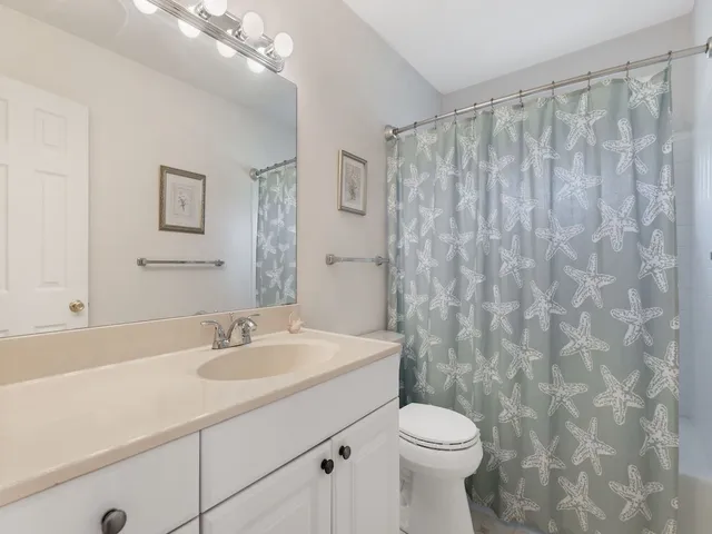a bathroom with a sink a toilet and shower curtain