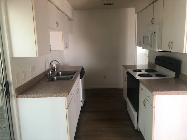 404 West Dittmar Road Austin, TX 78745 - Photo 4 of 15 Kitchen with white appliances, dark wood-style flooring, and white cabinetry