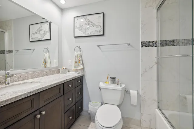 a bathroom with a granite countertop toilet sink and a mirror