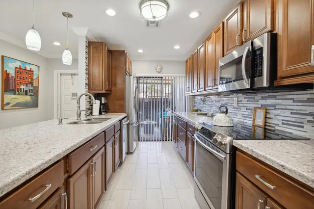 a kitchen with stainless steel appliances granite countertop a sink stove and cabinets