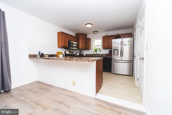 a kitchen with stainless steel appliances granite countertop a refrigerator sink and microwave