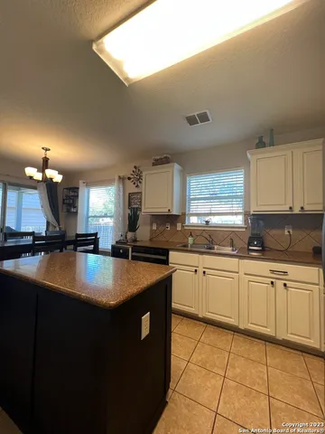 a kitchen with stainless steel appliances granite countertop a sink counter space and a view of living room
