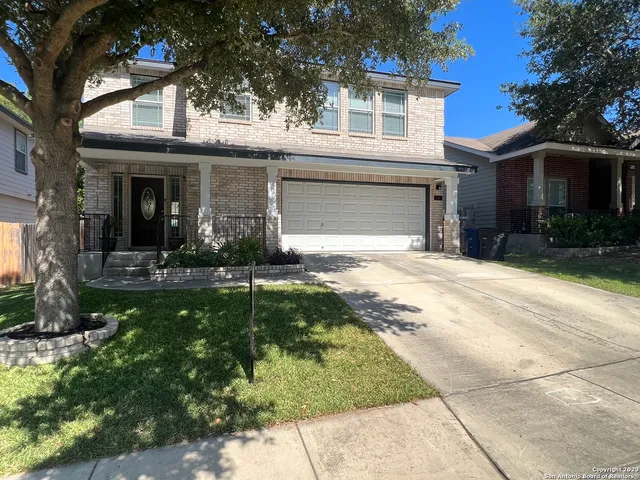a view of a white house with a yard and plants