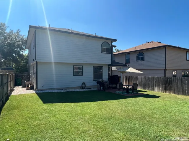a backyard of a house with table and chairs