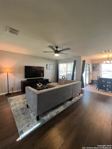 a living room with hard wood floors and a bed