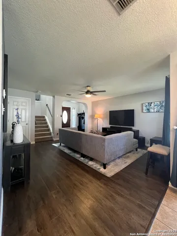 a living room with furniture and a wooden floor