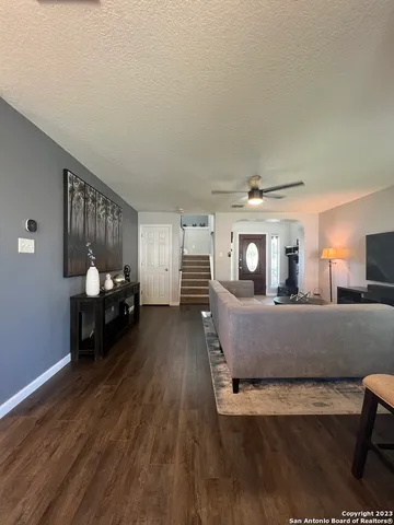 a living room with furniture and a wooden floor