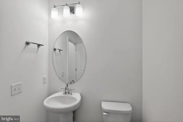 a bathroom with a toilet a sink and mirror
