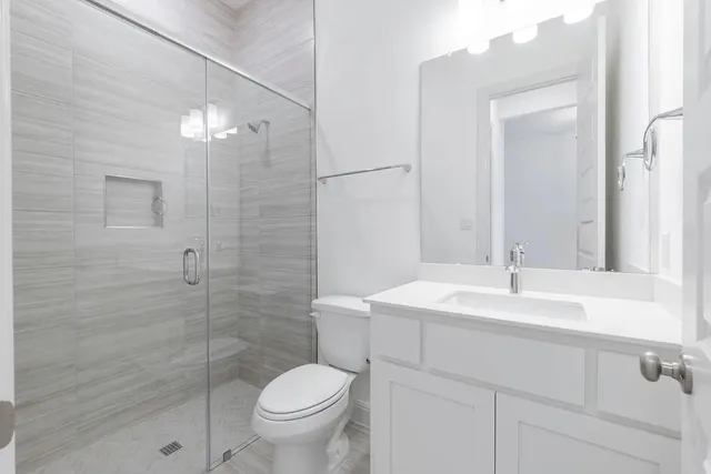 a bathroom with a sink a toilet and shower