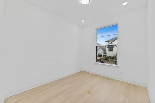 an empty room with a wooden floor and a window