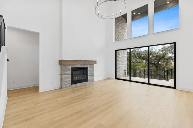 a view of an empty room with a fireplace and a window