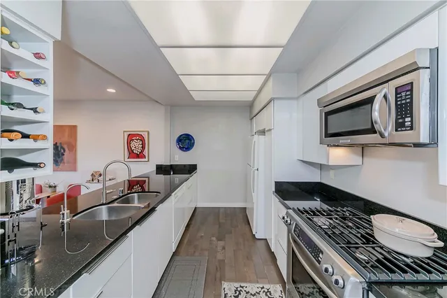 a kitchen with stainless steel appliances granite countertop a sink stove and cabinets