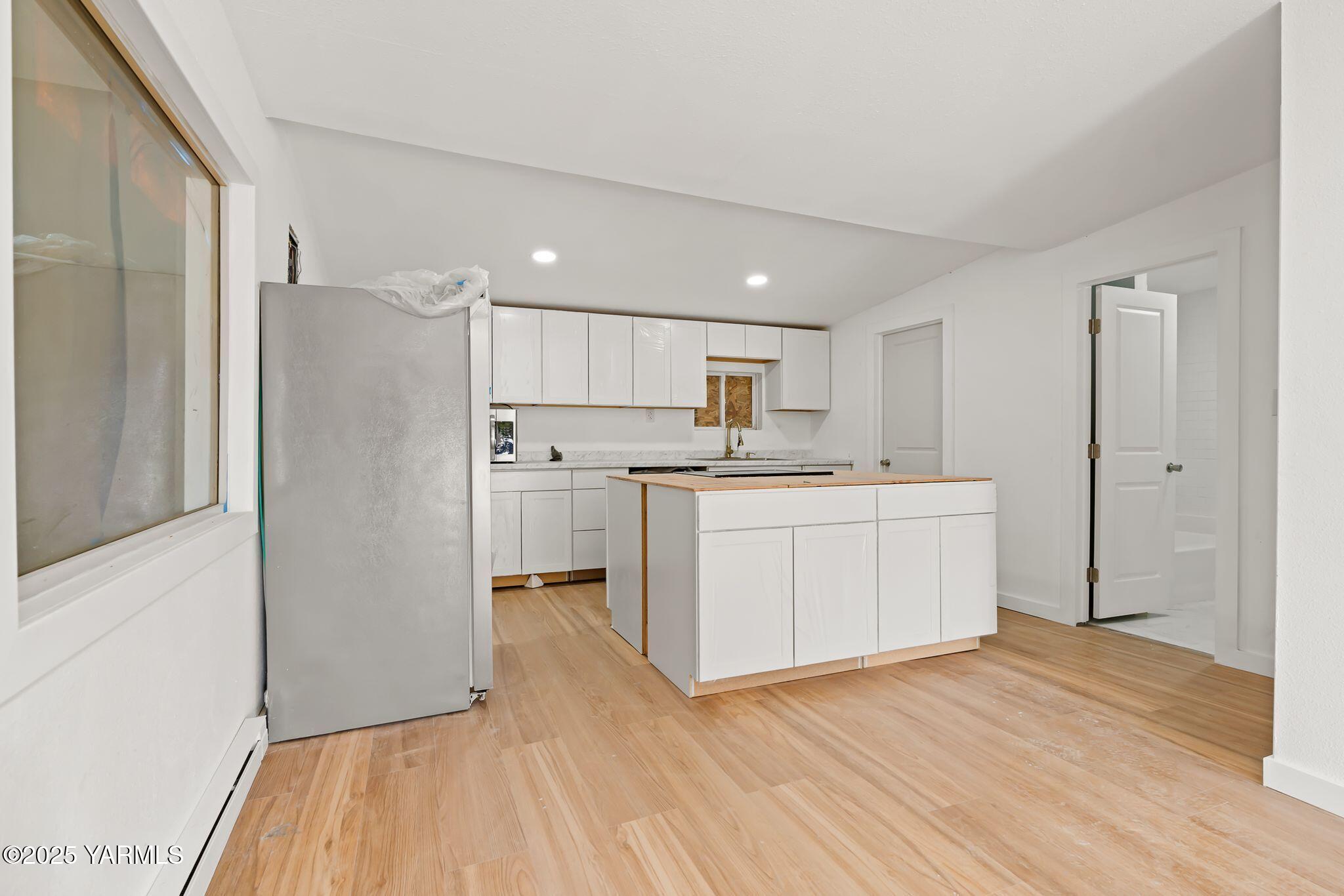 810 North 6th Avenue Yakima, WA 98902 - Photo 3 of 10 a kitchen with a refrigerator a sink and dishwasher with wooden floor