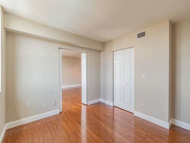 a view of an empty room with wooden floor