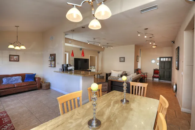 a living room with furniture a chandelier and a flat screen tv
