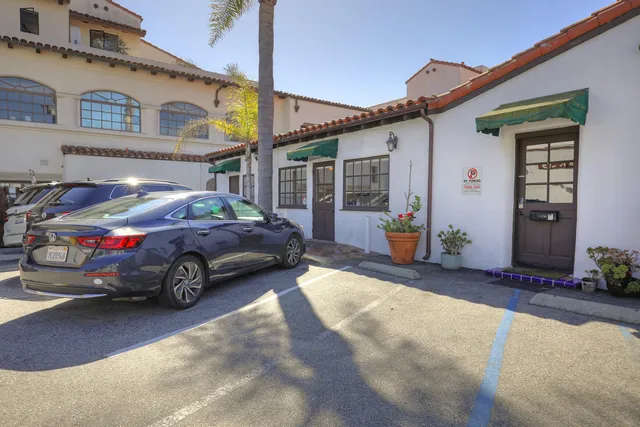 a view of a cars park in front of a building