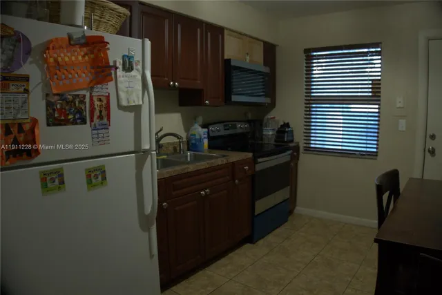 a kitchen with a refrigerator and a stove top oven