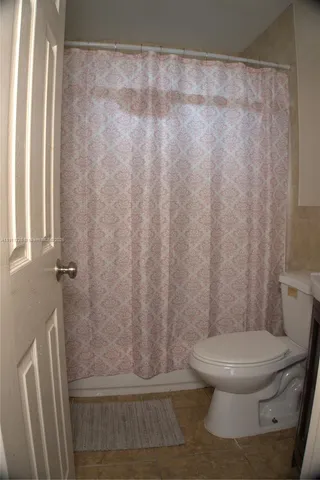 a white toilet sitting next to a shower curtain