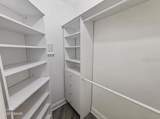 a view of a hallway with wooden floor kitchen view and a living room