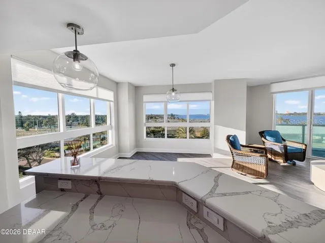 a living room with furniture a fireplace and a large window