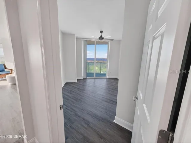 a living room with furniture large window and wooden floor