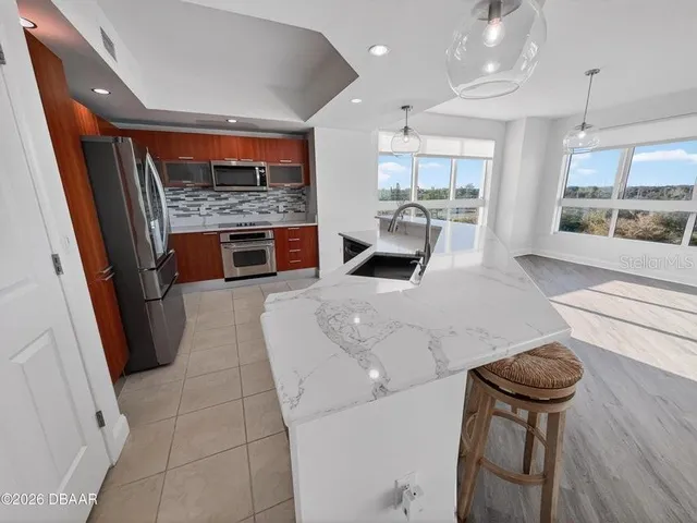 a kitchen with stainless steel appliances a refrigerator and a microwave