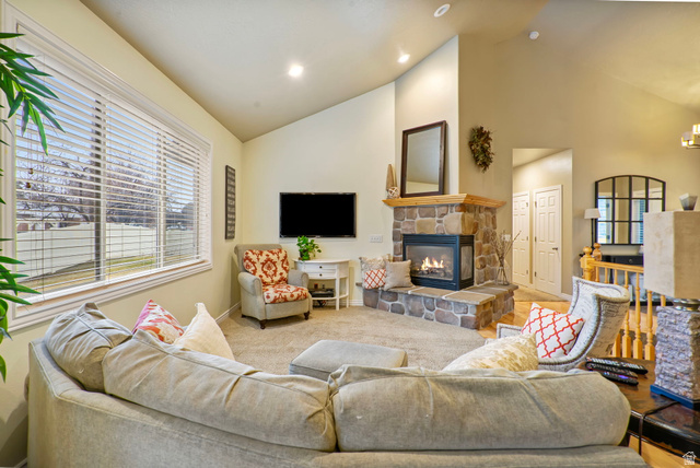 557 South 1470th Street East Springville, UT 84663 - Photo 7 of 46 Living room featuring vaulted ceiling, carpet flooring, and a stone fireplace