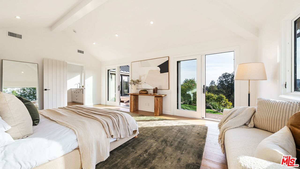 13146 Rivers Road Los Angeles, CA 90049 - Photo 18 of 42 a spacious bedroom with a large bed and a large window