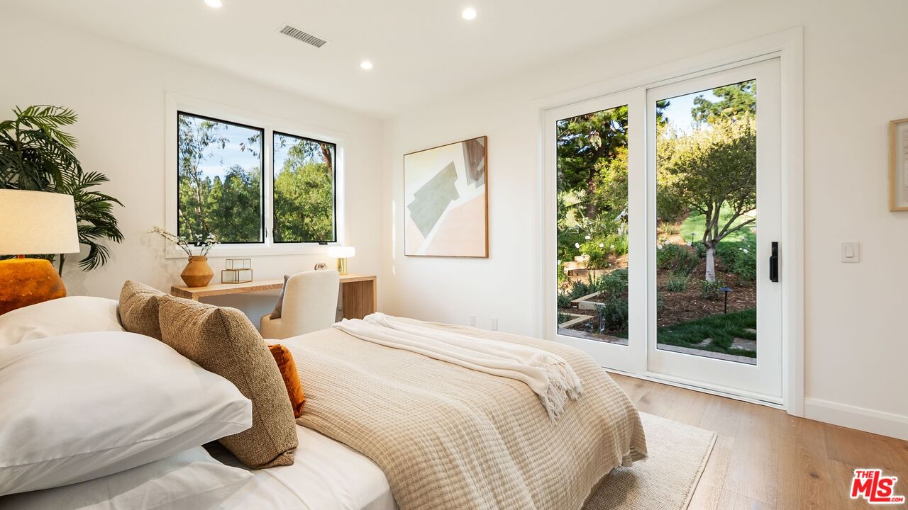 13146 Rivers Road Los Angeles, CA 90049 - Photo 29 of 42 a bedroom with bed and glass window