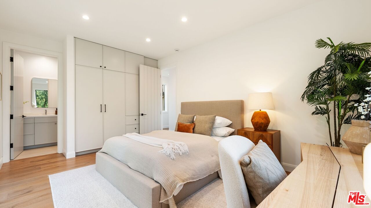 13146 Rivers Road Los Angeles, CA 90049 - Photo 30 of 42 a bedroom with a bed and a potted plant