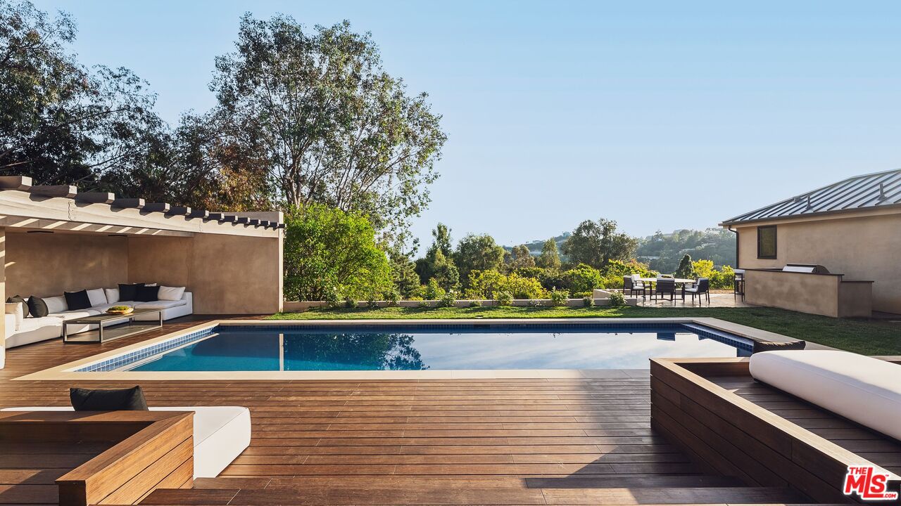 13146 Rivers Road Los Angeles, CA 90049 - Photo 3 of 42 a view of swimming pool with seating area and trees in the background