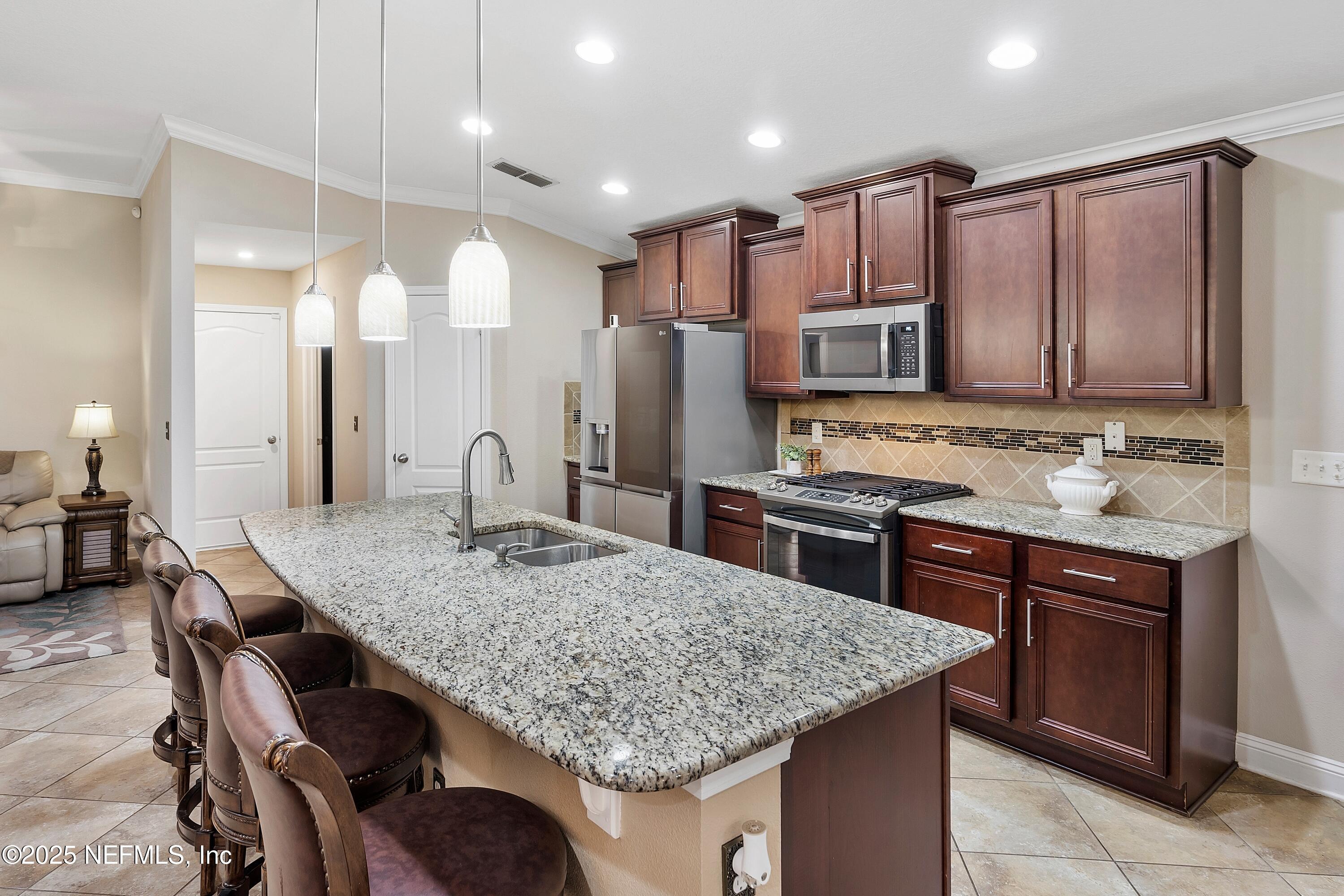78 Wayfare Lane Jacksonville, FL 32081 - Photo 13 of 61 a kitchen with kitchen island granite countertop wooden cabinets and a refrigerator