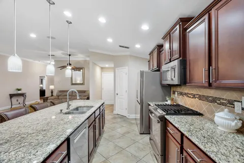 a kitchen with stainless steel appliances granite countertop a sink refrigerator and cabinets