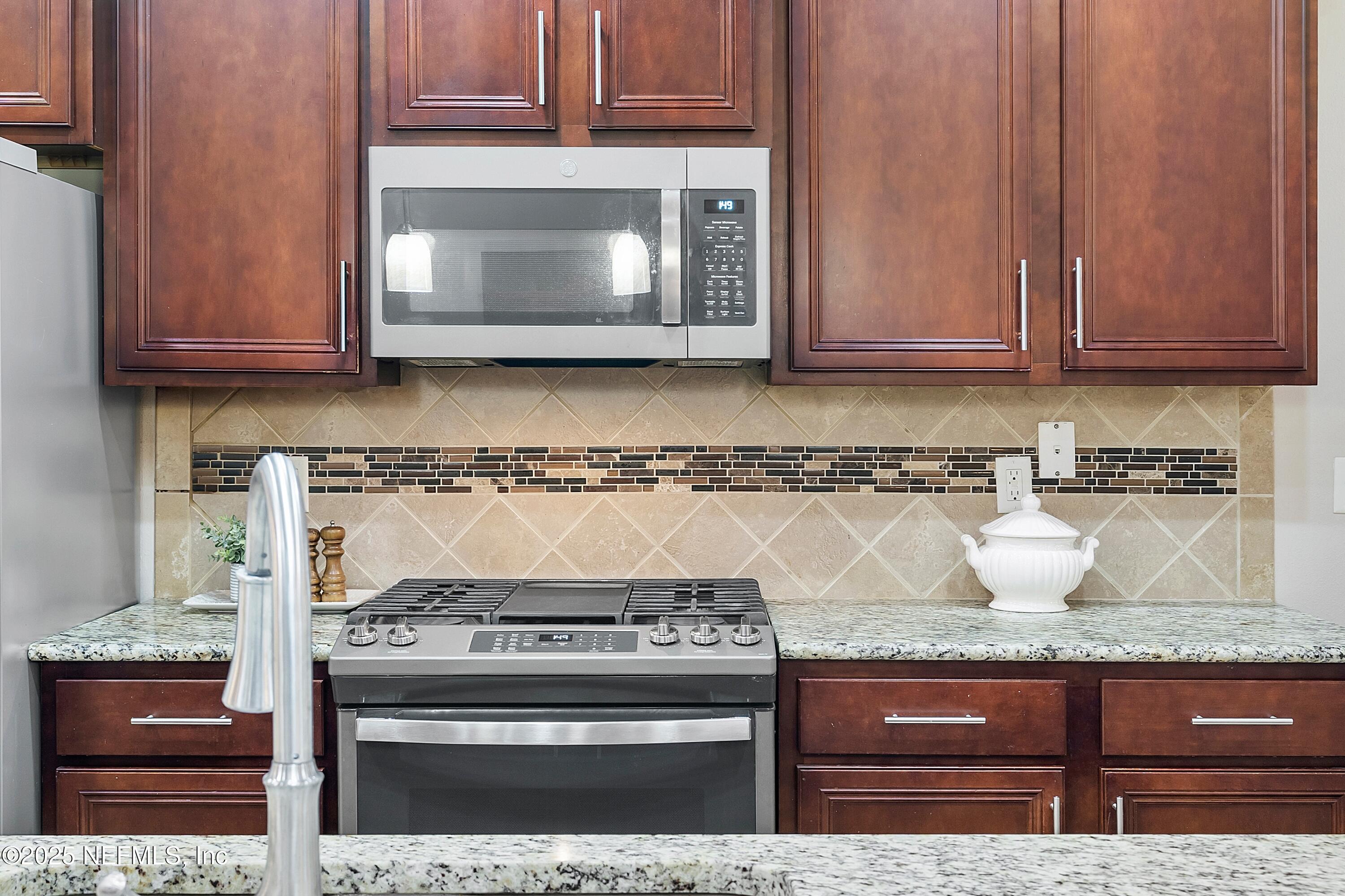 78 Wayfare Lane Jacksonville, FL 32081 - Photo 16 of 61 a kitchen with granite countertop a stove and a microwave oven