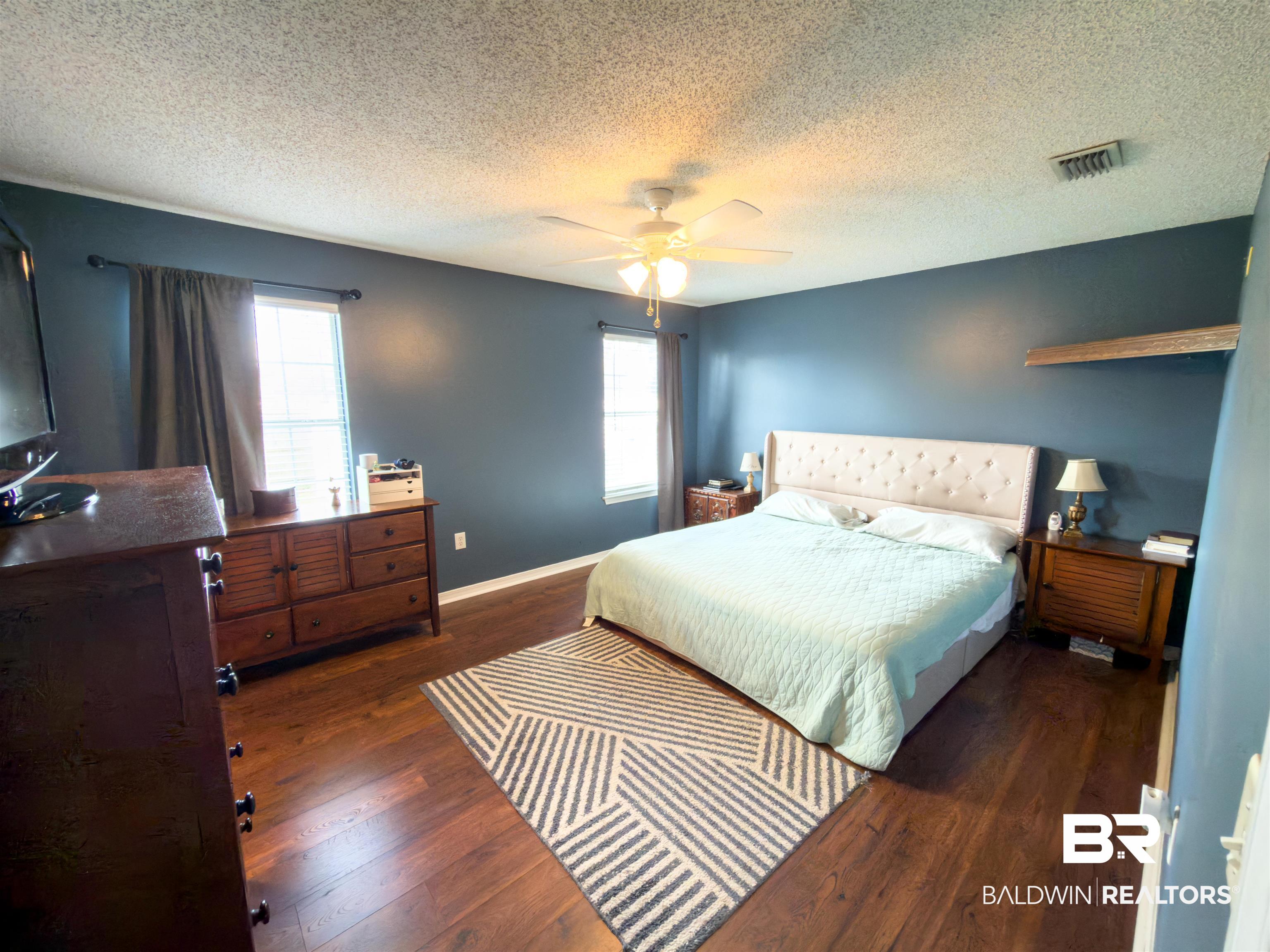 129 Pennbrooke Loop Foley, AL 36535 - Photo 24 of 44 Bedroom featuring dark wood-style floors, a ceiling fan, and a textured ceiling